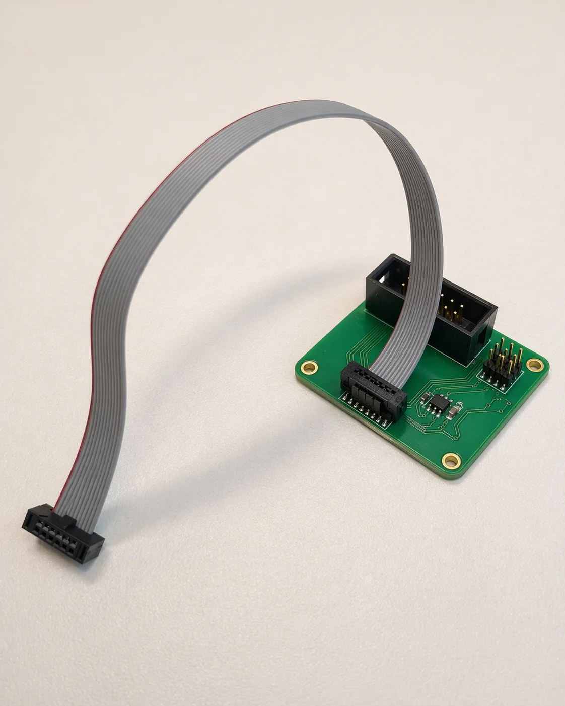 Small interface PCB with ribbon cable prepared for debug and integration correction