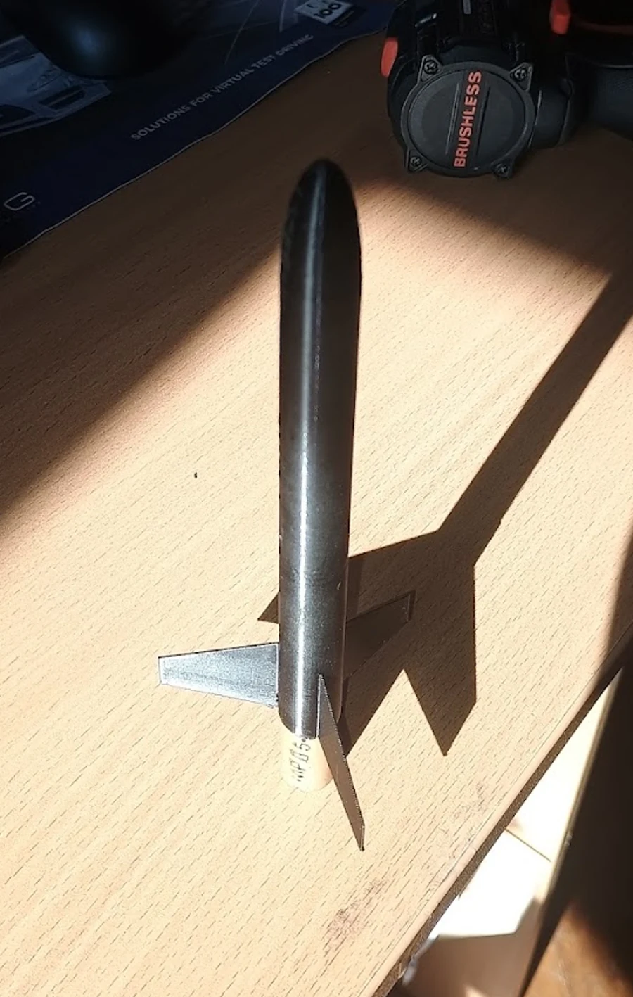 Physical compact rocket prototype standing on a desk