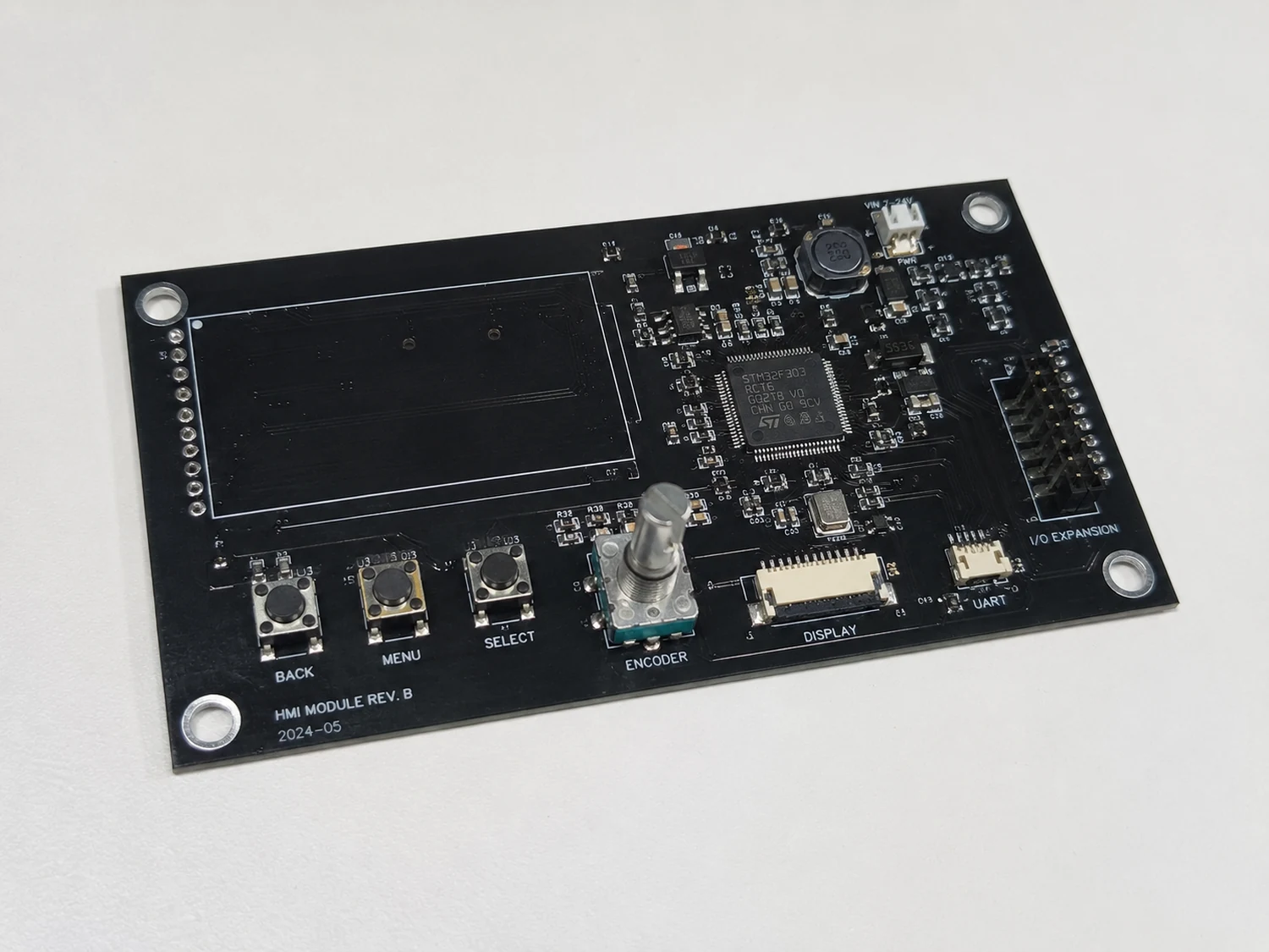 Black HMI and MCU PCB with display area, encoder, buttons, CAN-capable controller, and expansion connectors